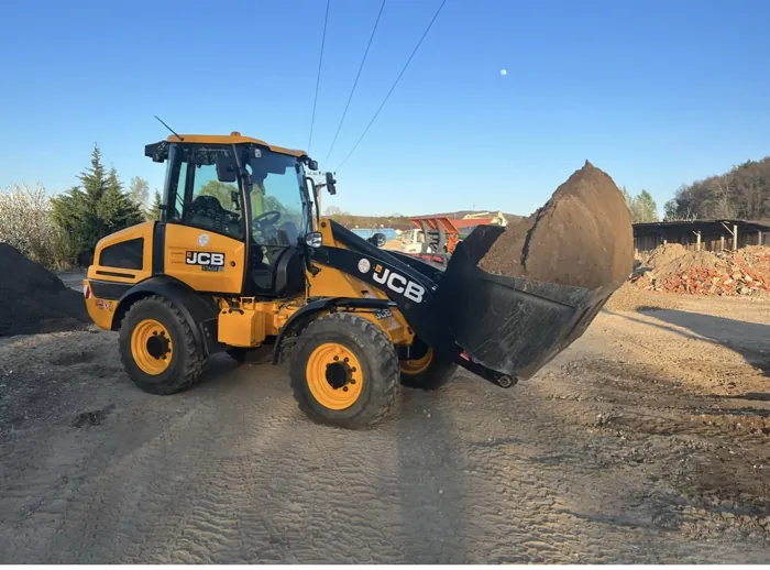 Kolesový nakladač JCB pri manipulácii s kamenivom